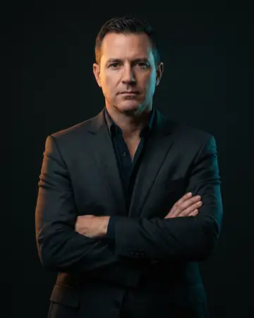 Grant Mihalek, senior trial attorney, photographed against a near-black backdrop