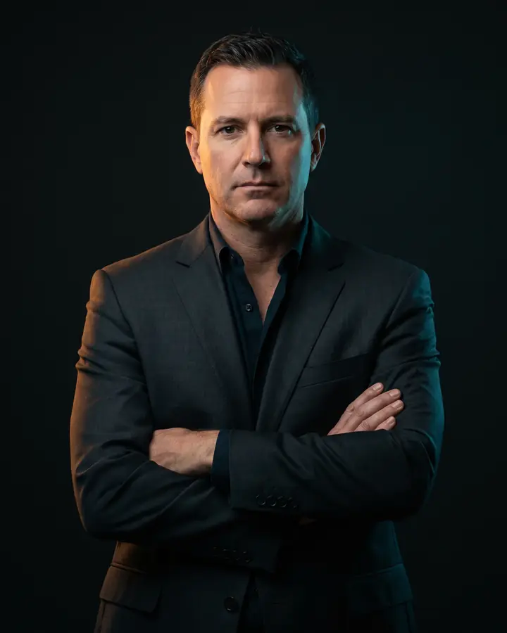 Grant Mihalek, senior trial attorney, photographed against a near-black backdrop